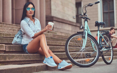 brunetka w turkusowej koszuli pije kawę podczas przerwy rowerowej