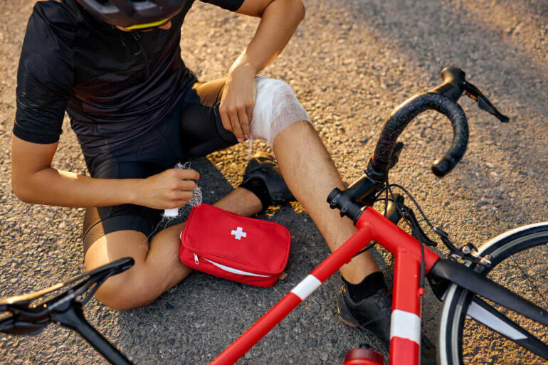 Mężczyzna opatruje się po wypadku na rowerze bandażami z apteki